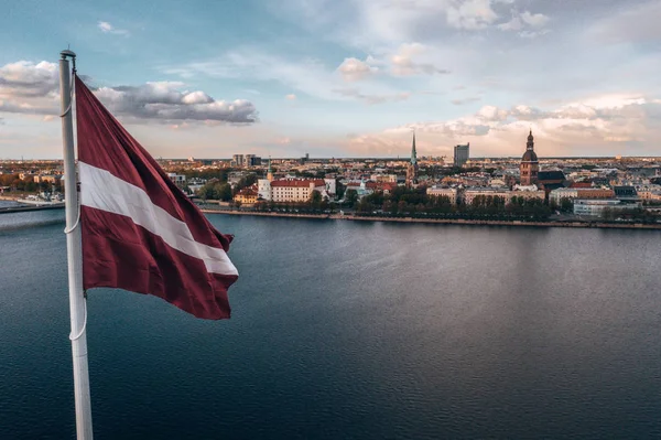 里加市的航空全景 前景是一面巨大的拉脱维亚国旗 黄金时间 — 图库照片