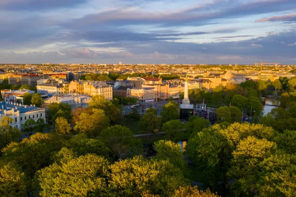 Letonya Milda - Özgürlük heykeli tarafından Riga üzerinde güzel günbatımı görünümü. Özgürlük anıtı. Konser için anıtın etrafında toplanan insanlar. 