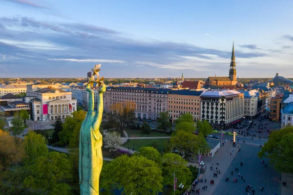 自由女神像在里加欣赏美丽的日落景色 拉脱维亚的米尔达 自由的纪念碑人们聚集在音乐会纪念碑周围 — 图库照片