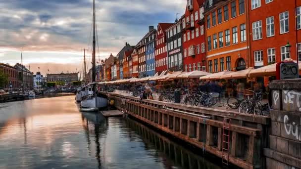 コペンハーゲン デンマークの旧市街で色の建物 ヨットや他のボートとNyhavn桟橋の風光明媚なタイムラプス夏の夕日の景色 — ストック動画