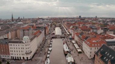 Danimarka'nın başkenti Kopenhag'ın eski kentinde eski evlerin ve eski gemilerin renkli cepheleri ile gün doğumunda Nyhavn'ın havadan görünümü.