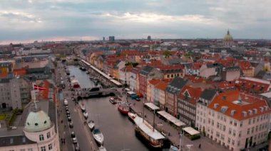 Danimarka'nın başkenti Kopenhag'ın eski kentinde eski evlerin ve eski gemilerin renkli cepheleri ile gün doğumunda Nyhavn'ın havadan görünümü.