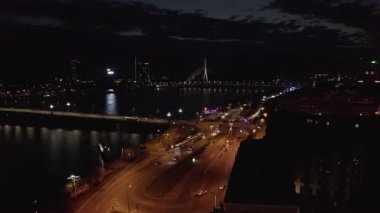 Flying over Riga city at night. Aerial view of the old town, river Daugava and bridges.