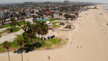 Beautiful aerial view of the skate park at the Venice beach in LA, California near the Pacific ocean. People skating down the skate park by the beach. Most popular skate park in the world.
