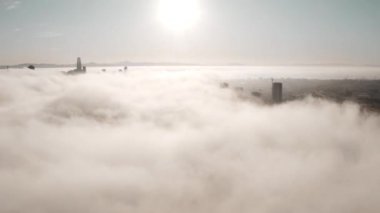 Rising and flying over the clouds during morning sunrise in San Francisco with skyscrapers rising above the clouds. Beautiful California, San Francisco.