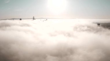 Rising and flying over the clouds during morning sunrise in San Francisco with skyscrapers rising above the clouds. Beautiful California, San Francisco.