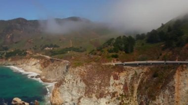 Scenic panoramic time lapse view of clouds passing historic Bixby Creek Bridge along world famous Highway 1 during summer, Monterey County, California, USA