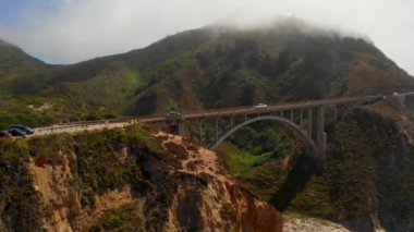 Scenic panoramic time lapse view of clouds passing historic Bixby Creek Bridge along world famous Highway 1 during summer, Monterey County, California, USA