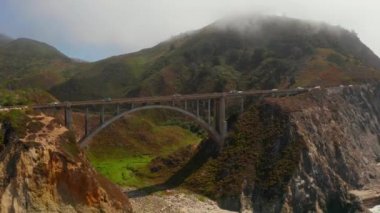 Scenic panoramic time lapse view of clouds passing historic Bixby Creek Bridge along world famous Highway 1 during summer, Monterey County, California, USA