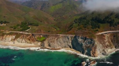 Scenic panoramic time lapse view of clouds passing historic Bixby Creek Bridge along world famous Highway 1 during summer, Monterey County, California, USA
