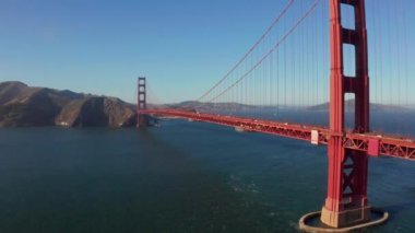 Beautiful aerial view of the golden gate bridge in San Francisco from above with cars driving down the bridge.
