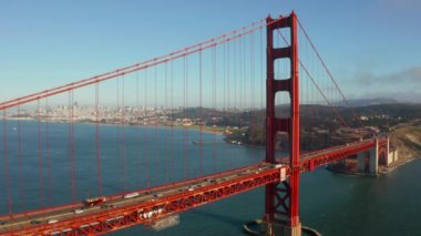 Beautiful aerial view of the golden gate bridge in San Francisco from above with cars driving down the bridge.
