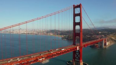 Beautiful aerial view of the golden gate bridge in San Francisco from above with cars driving down the bridge.