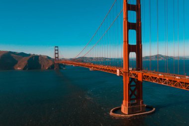 Golden Gate Köprüsü 'nün San Francisco, Kaliforniya' daki Golden Gate Ulusal Eğlence Alanı üzerindeki hava günbatımı manzarası..