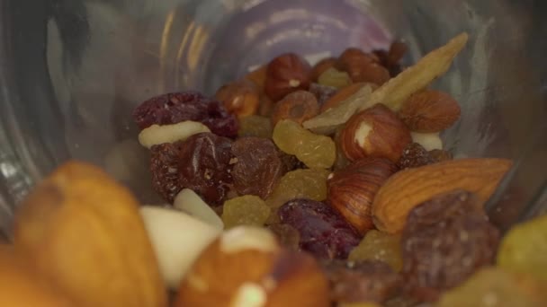 ガラス瓶や木製のテーブルにナッツ 種子やドライフルーツのマクロビュー — ストック動画
