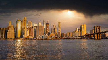 Brooklyn Parkı 'ndan Brooklyn Köprüsü' nün büyülü akşam mor gün batımı manzarası Hudson Nehri 'nin diğer tarafındaki Manhattan manzaralı..