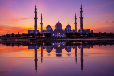Günbatımında Abu Dabi 'deki Büyük Cami' nin büyülü mor günbatımı. Şeyh Zayed Camii 'nin dış görünümü BAE.