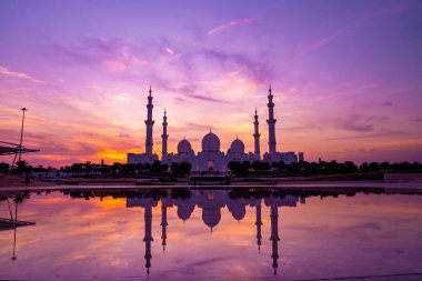 Günbatımında Abu Dabi 'deki Büyük Cami' nin büyülü mor günbatımı. Şeyh Zayed Camii 'nin dış görünümü BAE.