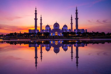 Günbatımında Abu Dabi 'deki Büyük Cami' nin büyülü mor günbatımı. Şeyh Zayed Camii 'nin dış görünümü BAE.