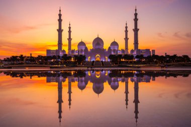 Günbatımında Abu Dabi 'deki Büyük Cami' nin büyülü mor günbatımı. Şeyh Zayed Camii 'nin dış görünümü BAE.