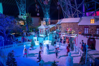 ABU DHABI, BAE - 5 Mayıs 2020: Çocuklar karda oynarken ve Eğlence Merkezi Ferrari World 'de kardan adam yaparken kış harikalar diyarı gibi büyülü bir Noel ruhu