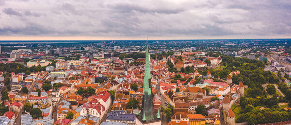 Tallinn is a medieval city in Estonia in the Baltics. Aerial view of the old town of Tallinn with orange roofs and narrow streets below.