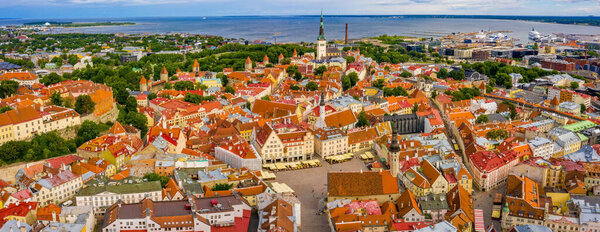 Tallinn is a medieval city in Estonia in the Baltics. Aerial view of the old town of Tallinn with orange roofs and narrow streets below.