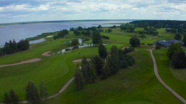 Göl kenarındaki golf sahasında mavi gökyüzü arka planlı hava manzarası