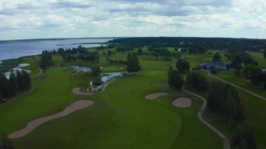 Göl kenarındaki golf sahasında mavi gökyüzü arka planlı hava manzarası