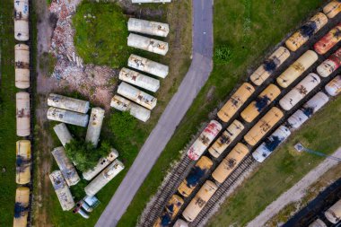 Riga, Letonya. 10 Temmuz 2020. Kargo trenlerinin üst hava görüntüsü. Tren istasyonundaki renkli yük trenlerinin uçan insansız hava aracı görüntüsü. Demiryolunda malları olan vagonlar..