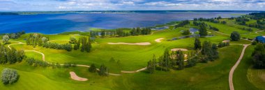 Göl kenarındaki golf sahasında mavi gökyüzü arka planlı hava manzarası