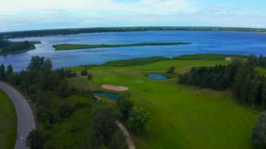 Göl kenarındaki golf sahasında mavi gökyüzü arka planlı hava manzarası