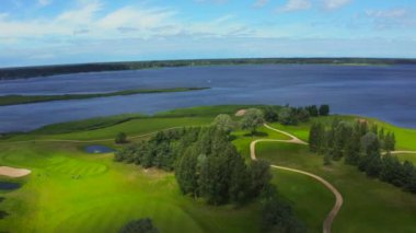 Göl kenarındaki golf sahasında mavi gökyüzü arka planlı hava manzarası