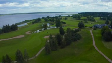 Göl kenarındaki golf sahasında mavi gökyüzü arka planlı hava manzarası