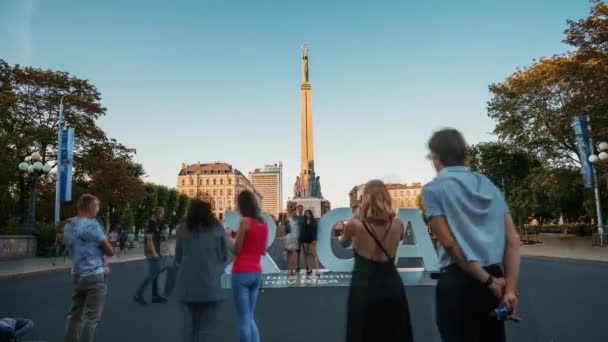 ラトビアのリガ 2020年8月5日 自由の記念碑ミルダに駆け寄り ラトビアのリガの巨大な看板の近くで写真を撮る人々のタイムラプスビュー — ストック動画
