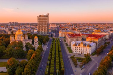 Riga Center 'ın güzel hava manzarası ve Daugava nehri üzerindeki Vansu köprüsü gün batımında. Letonya 'nın başkenti Riga' nın aydınlanmış manzarası.