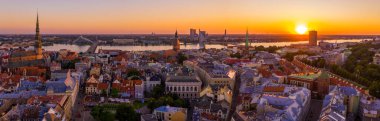 Riga Center 'ın güzel hava manzarası ve Daugava nehri üzerindeki Vansu köprüsü gün batımında. Letonya 'nın başkenti Riga' nın aydınlanmış manzarası.