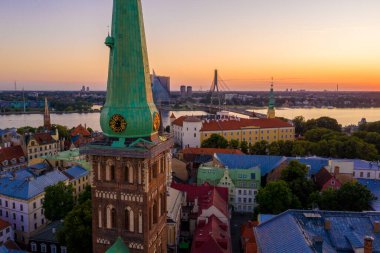 Riga Center 'ın güzel hava manzarası ve Daugava nehri üzerindeki Vansu köprüsü gün batımında. Letonya 'nın başkenti Riga' nın aydınlanmış manzarası.