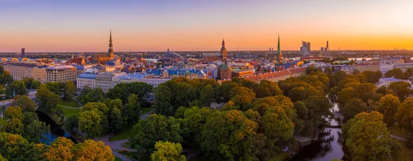 Riga Center 'ın güzel hava manzarası ve Daugava nehri üzerindeki Vansu köprüsü gün batımında. Letonya 'nın başkenti Riga' nın aydınlanmış manzarası.