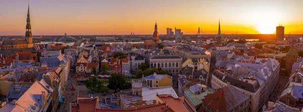 Riga Center 'ın güzel hava manzarası ve Daugava nehri üzerindeki Vansu köprüsü gün batımında. Letonya 'nın başkenti Riga' nın aydınlanmış manzarası.