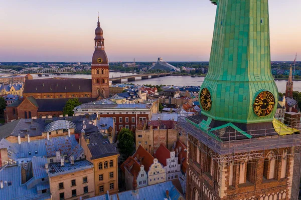 Riga Center 'ın güzel hava manzarası ve Daugava nehri üzerindeki Vansu köprüsü gün batımında. Letonya 'nın başkenti Riga' nın aydınlanmış manzarası.