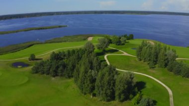 Göl kenarındaki golf sahasında mavi gökyüzü arka planlı hava manzarası