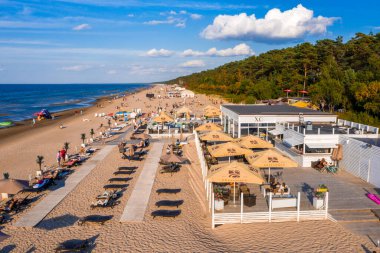 Dzintari, Jurmala, Letonya - 12 Ağustos 2020: İnsanlar Jurmala tatil beldesi X.O. 'daki Baltık Körfezi sahilindeki güneşli bahar gününün tadını çıkarıyorlar. Letonya 'daki restoran.
