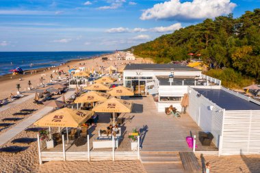 Dzintari, Jurmala, Letonya - 12 Ağustos 2020: İnsanlar Jurmala tatil beldesi X.O. 'daki Baltık Körfezi sahilindeki güneşli bahar gününün tadını çıkarıyorlar. Letonya 'daki restoran.
