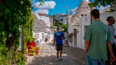 Alberobello, İtalya. 10 Temmuz 2020. İtalya 'nın Puglia bölgesindeki Bari eyaletinin Arbelobello kentindeki geleneksel trulli evlerinin zaman çizelgesi. Küçük beyaz evleri olan güzel eski Arbelobello kasabası. 