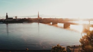 Riga, Letonya 'da güzel bir gün doğumu. Arka planda Riga eski kasabasıyla Daugava nehrinin üzerinde uçuyor..