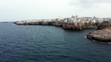 Polignano a Mare kasabası, Puglia bölgesi, İtalya ve Avrupa 'nın ilkbahar panoramik manzarası. Adriyatik denizinin muhteşem manzarası. Seyahat konsepti geçmişi. Turkuaz deniz suyu.