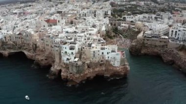 Polignano a Mare kasabası, Puglia bölgesi, İtalya ve Avrupa 'nın ilkbahar panoramik manzarası. Adriyatik denizinin muhteşem manzarası. Seyahat konsepti geçmişi. Turkuaz deniz suyu.