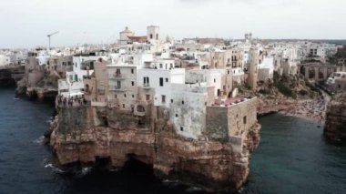 Polignano a Mare kasabası, Puglia bölgesi, İtalya ve Avrupa 'nın ilkbahar panoramik manzarası. Adriyatik denizinin muhteşem manzarası. Seyahat konsepti geçmişi. Turkuaz deniz suyu.