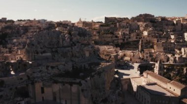 Antik Matera (Sassi di Matera) şehrinin güneş doğarken güzel altın sabah ışığı altında havadan panoramik görüntüsü, Güney İtalya, Basilicata. Yukarıdan muhteşem bir eski kasaba. Sihirli İtalya.
